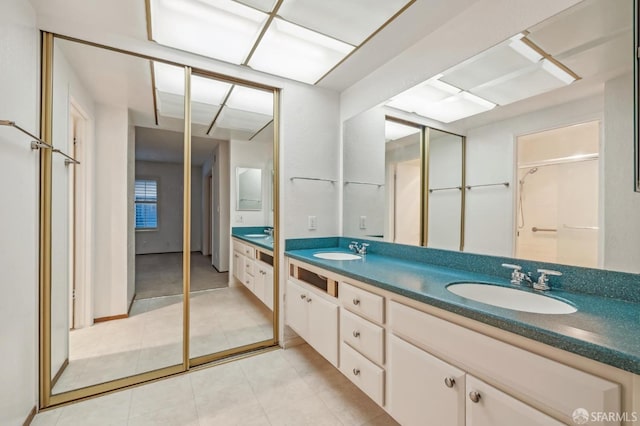 bathroom with double vanity, tile patterned floors, and a sink