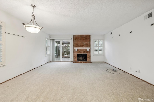 unfurnished living room with visible vents, a healthy amount of sunlight, a textured ceiling, and carpet flooring