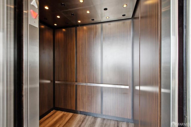 interior details with recessed lighting, elevator, and wood finished floors