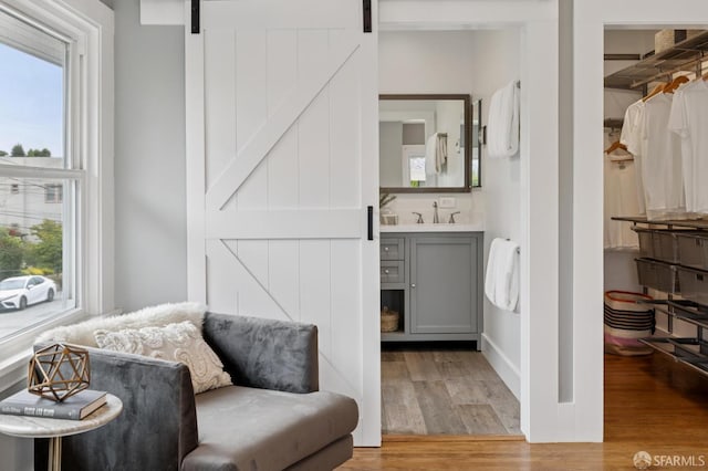 4145 Emerald St, Oakland, CA 94609 - living area featuring a barn door, healthy amount of natural light, and light wood-type flooring
