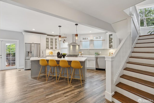 4145 Emerald St, Oakland, CA 94609 - kitchen with stainless steel appliances, wall chimney range hood, light countertops, white cabinetry, and recessed lighting