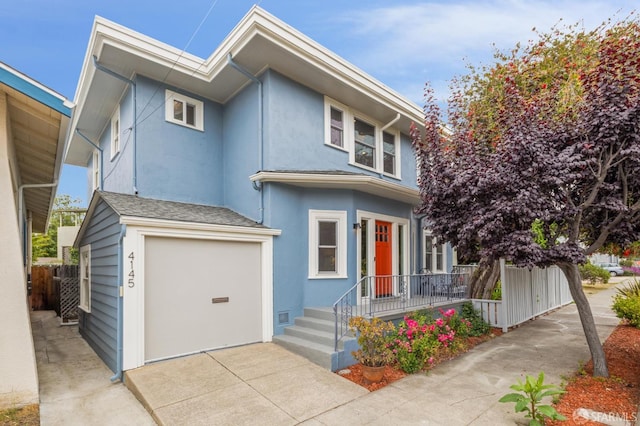 4145 Emerald St, Oakland, CA 94609 - view of front of home featuring an attached garage, stucco siding, and driveway