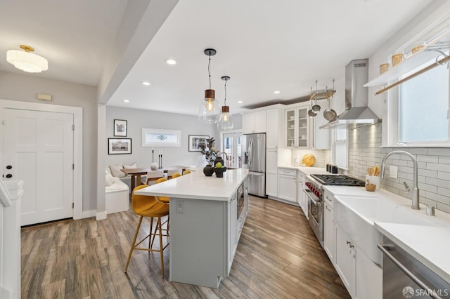 4145 Emerald St, Oakland, CA 94609 - kitchen with exhaust hood, stainless steel appliances, recessed lighting, a breakfast bar area, and decorative backsplash