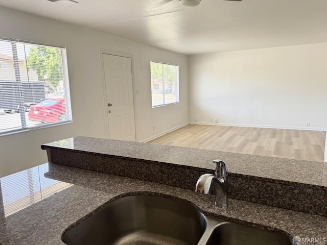 1200 Lemontree Way Unit 1, Antioch, CA 94509 - kitchen with light wood finished floors, a ceiling fan, and dark stone countertops
