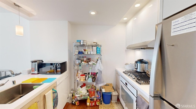 555 Fulton St Unit 322, San Francisco, CA 94102 - kitchen with stainless steel appliances, under cabinet range hood, light countertops, white cabinets, and pendant lighting