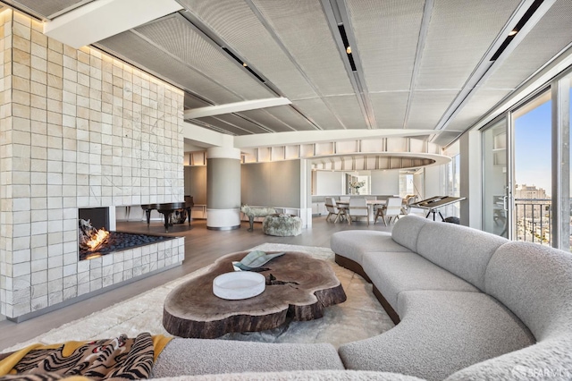 living room featuring a tiled fireplace and concrete floors