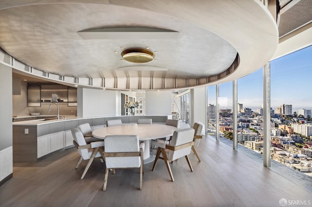 dining area with floor to ceiling windows, wood-type flooring, and sink