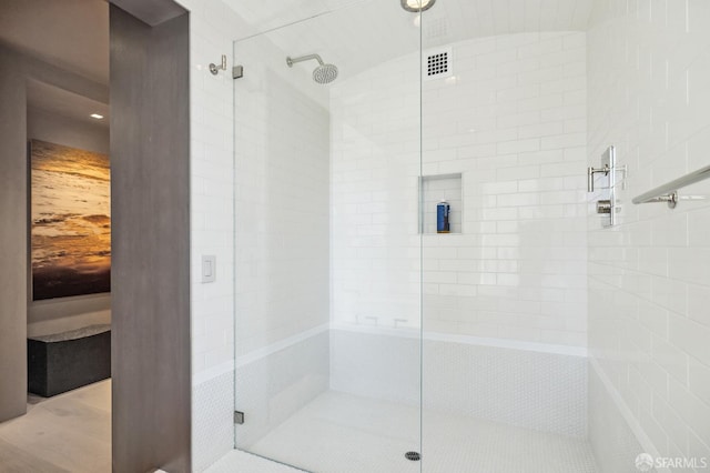 bathroom featuring a shower with door and vaulted ceiling