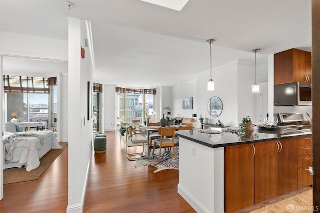 88 King St Unit 906, San Francisco, CA 94107 - kitchen featuring stainless steel microwave, open floor plan, wood finished floors, and brown cabinets