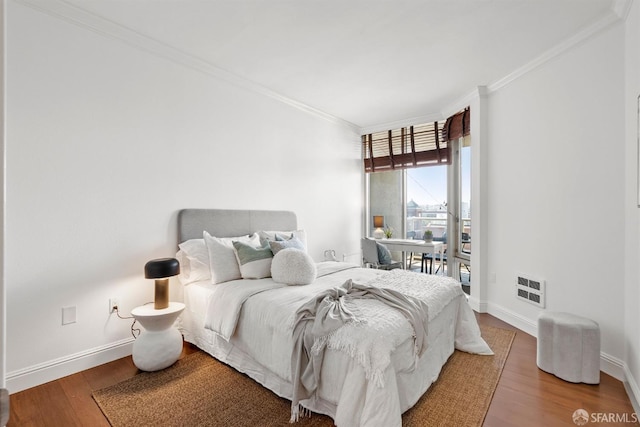 bedroom featuring ornamental molding, hardwood / wood-style floors, and heating unit