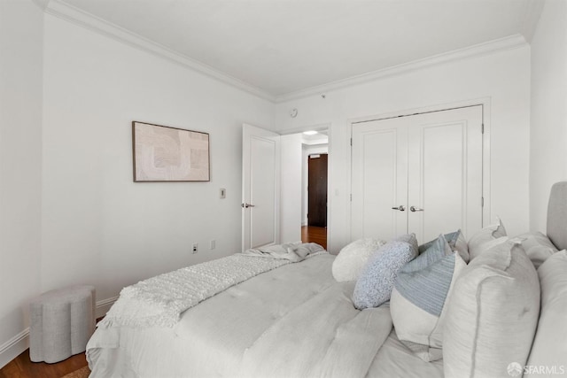 bedroom with a closet, ornamental molding, and wood-type flooring