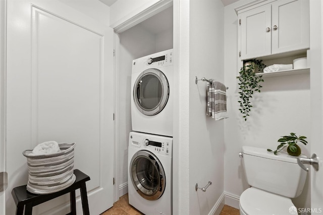 laundry room with baseboards, laundry area, and stacked washer / dryer
