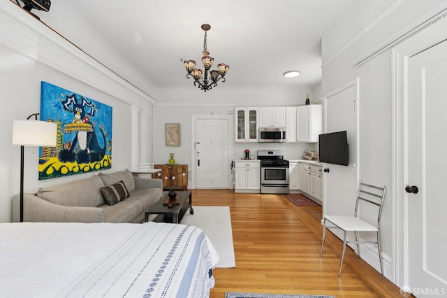 1932 Fell St Unit 1, San Francisco, CA 94117 - bedroom with light wood finished floors, a chandelier, and decorative columns
