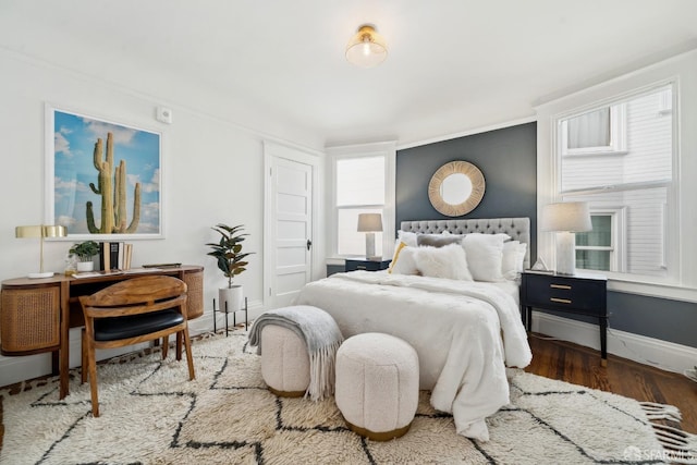 bedroom with dark hardwood / wood-style flooring, multiple windows, and ornamental molding