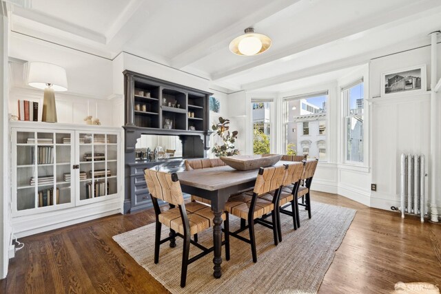 dining room with radiator, dark hardwood / wood-style floors, and beam ceiling