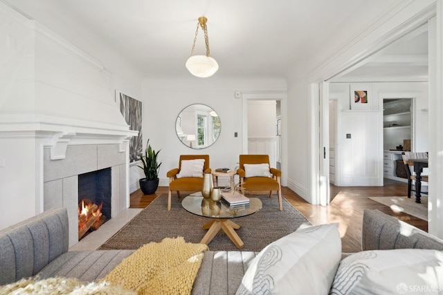 living room with a tiled fireplace and hardwood / wood-style flooring