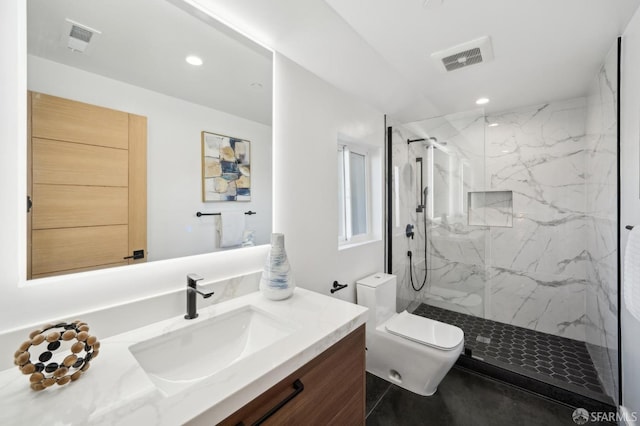 bathroom featuring tiled shower, vanity, and toilet