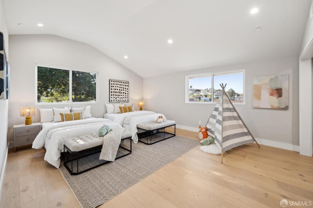 bedroom with lofted ceiling and light hardwood / wood-style floors