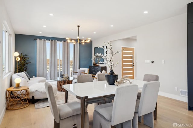 dining room with a notable chandelier and light wood-type flooring