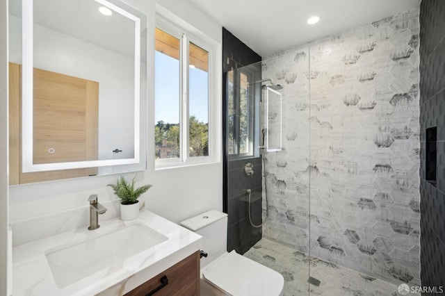 bathroom featuring tiled shower, vanity, and toilet