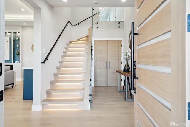 entryway with a towering ceiling and light hardwood / wood-style floors