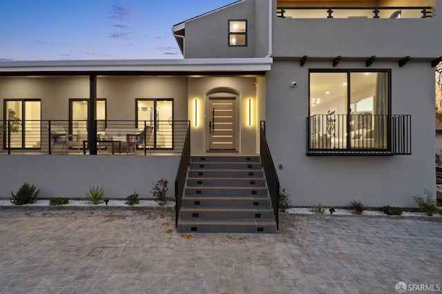 exterior entry at dusk with a balcony