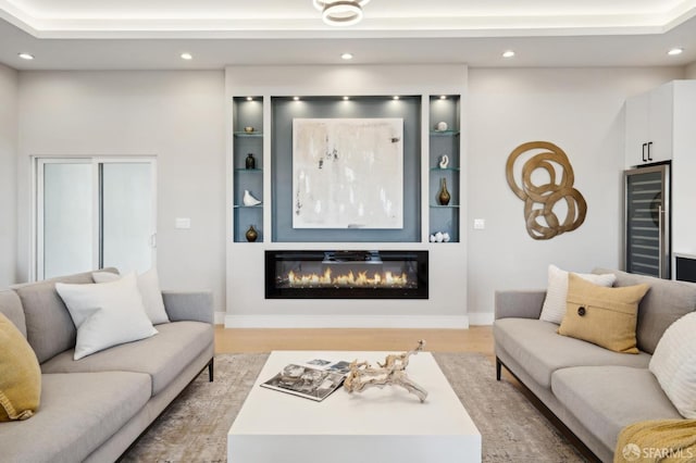 living room featuring built in features, beverage cooler, and light hardwood / wood-style floors