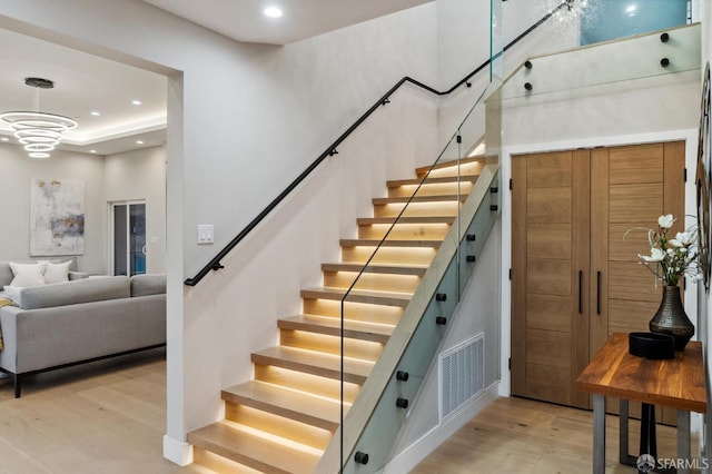 stairs with hardwood / wood-style flooring and a high ceiling