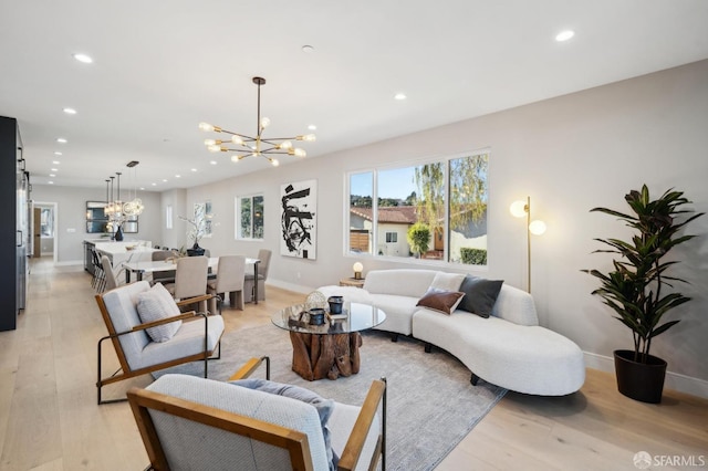 living room featuring an inviting chandelier and light hardwood / wood-style flooring