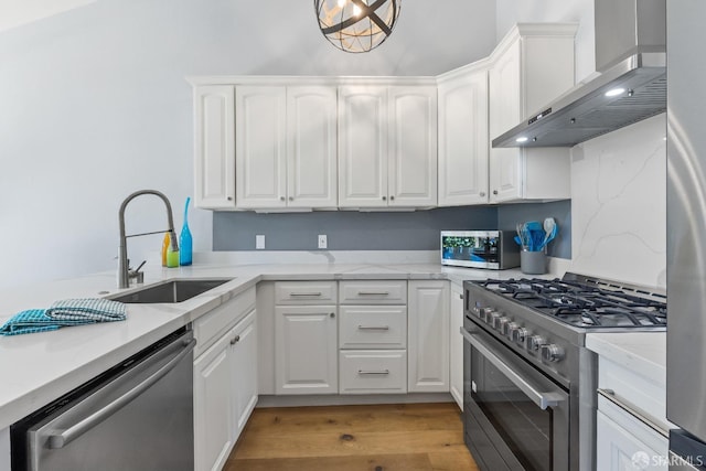 1541 Moraga Way, Moraga, CA 94556 - kitchen featuring wall chimney range hood, stainless steel appliances, a sink, white cabinetry, and light wood-type flooring