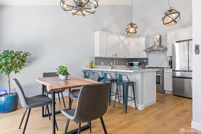 1541 Moraga Way, Moraga, CA 94556 - kitchen with appliances with stainless steel finishes, wall chimney exhaust hood, a chandelier, white cabinets, and a high ceiling
