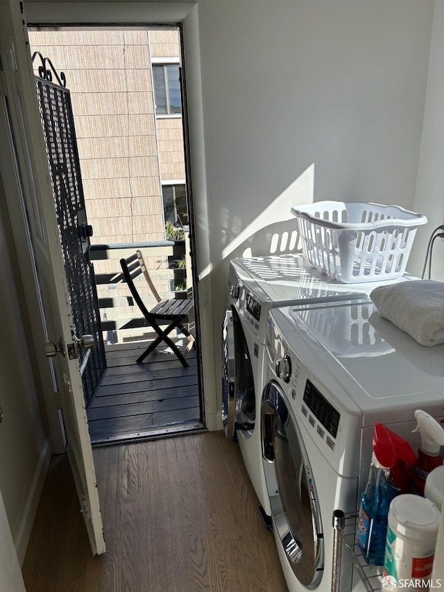 clothes washing area with laundry area, wood finished floors, and washing machine and dryer