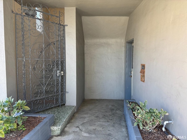 property entrance with a gate and stucco siding