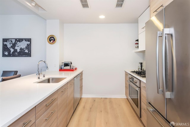451 Donahue St Unit 207, San Francisco, CA 94124 - kitchen featuring stainless steel appliances, a sink, light wood-style floors, light countertops, and modern cabinets