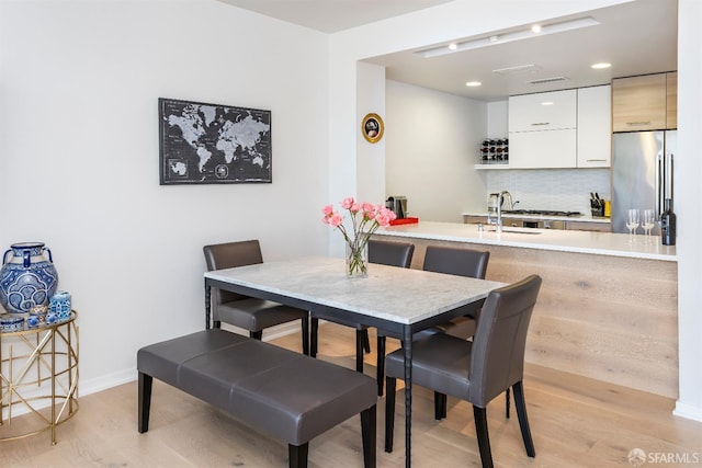 451 Donahue St Unit 207, San Francisco, CA 94124 - dining space with light wood finished floors, baseboards, bar, and recessed lighting