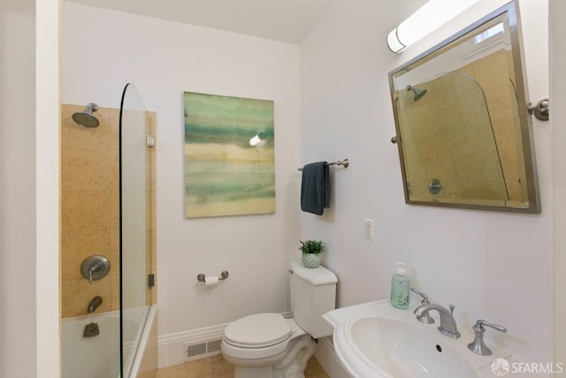 full bathroom featuring toilet, tiled shower / bath combo, sink, and tile patterned floors