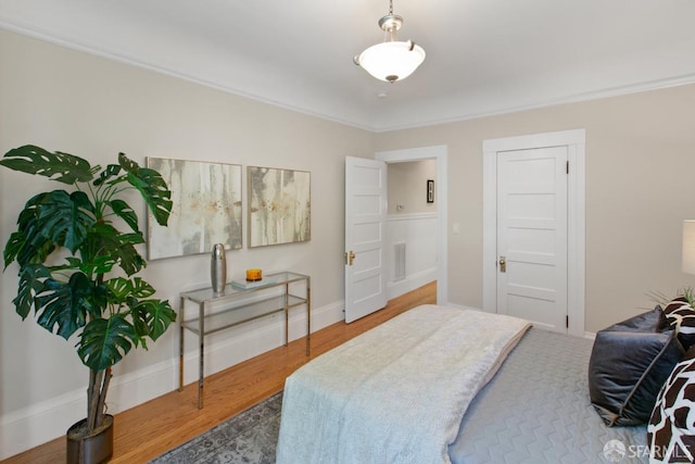 bedroom featuring ornamental molding and hardwood / wood-style flooring