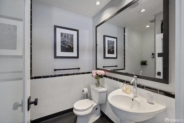 bathroom with sink, tile walls, tile patterned flooring, and toilet