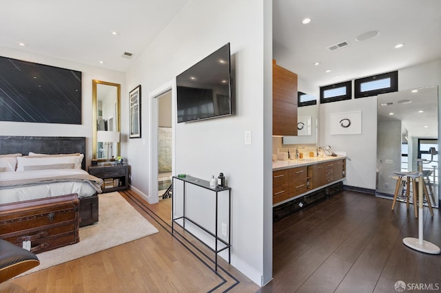 bedroom featuring connected bathroom and hardwood / wood-style floors