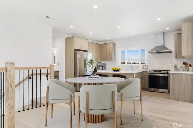 269 E Ave, San Bruno, CA 94066 - kitchen featuring wall chimney range hood, stainless steel appliances, modern cabinets, light countertops, and light brown cabinets
