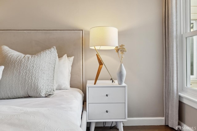 bedroom with baseboards and wood finished floors