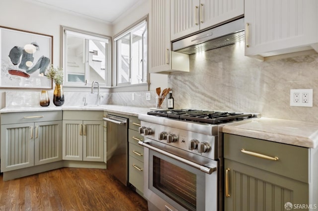 kitchen with dark wood finished floors, stainless steel appliances, backsplash, a sink, and under cabinet range hood