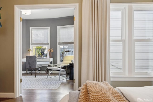 bedroom with ornamental molding, dark wood-style flooring, and baseboards