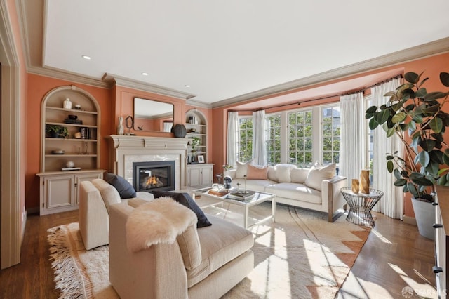 living area with built in features, recessed lighting, a fireplace, and ornamental molding