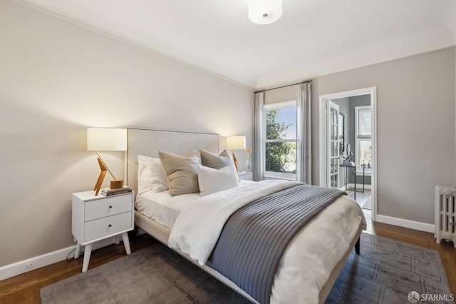 bedroom with dark wood-style floors, radiator heating unit, and baseboards