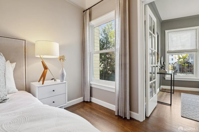 bedroom featuring dark wood-style floors, baseboards, and crown molding