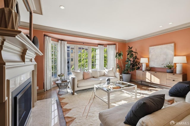 living room featuring recessed lighting, a fireplace, wood finished floors, and crown molding