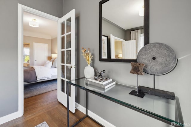 interior space with baseboards, french doors, wood finished floors, and crown molding