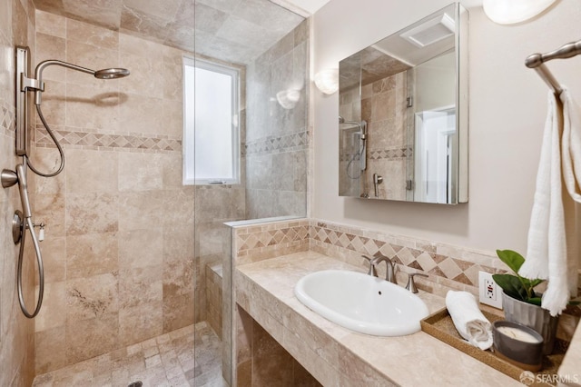 bathroom featuring a sink and a tile shower