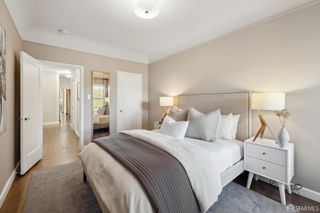 bedroom with dark wood-style floors and baseboards